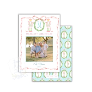 May include: A Christmas card with a family photo, featuring a light blue border and the text "Merriest Christmas". The card has a pink ribbon and nutcracker design. The back of the card has a repeating pattern of the same design.