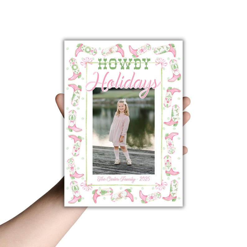May include: A holiday card featuring a young girl in a pink dress, framed by a border of pink cowboy boots and floral accents. The words "HOWDY Holidays" are displayed in green and pink, with "The Carter Family - 2025" at the bottom.