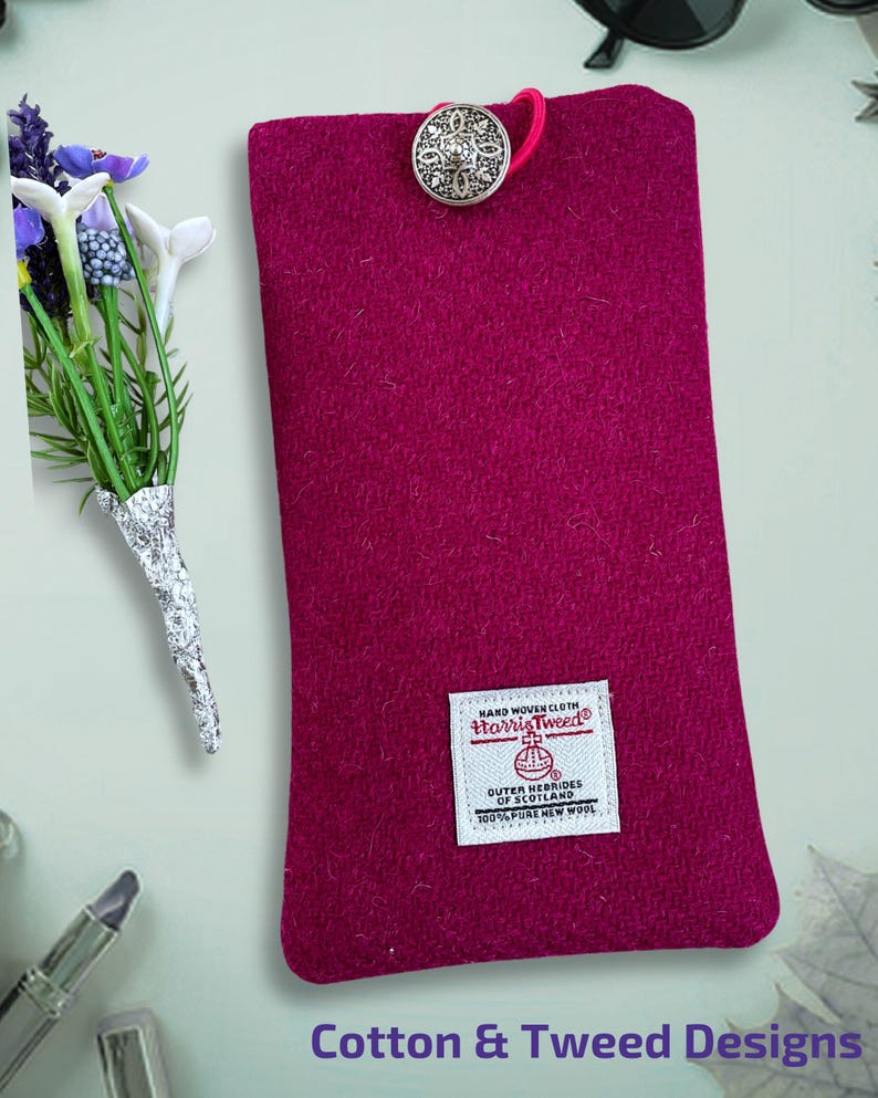 Pu&ograve; includere: Una custodia rettangolare in lana color magenta con una chiusura a bottone decorativo argentato e un passante elastico rosa. Un'etichetta bianca Harris Tweed &egrave; cucita sul davanti con la scritta Hand Woven Cloth Harris Tweed Outer Hebrides of Scotland 100% Pure New Wool.