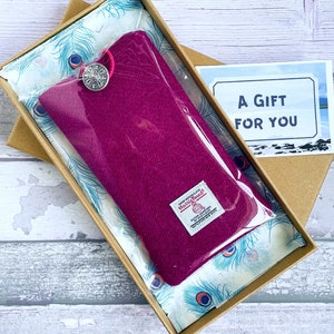 Pu&ograve; includere: Una custodia in lana magenta con chiusura a bottone argentato, dotata di etichetta Harris Tweed, confezionata in una scatola di cartone marrone foderata con carta velina a motivo di piume di pavone e un biglietto con scritto A GIFT FOR YOU.