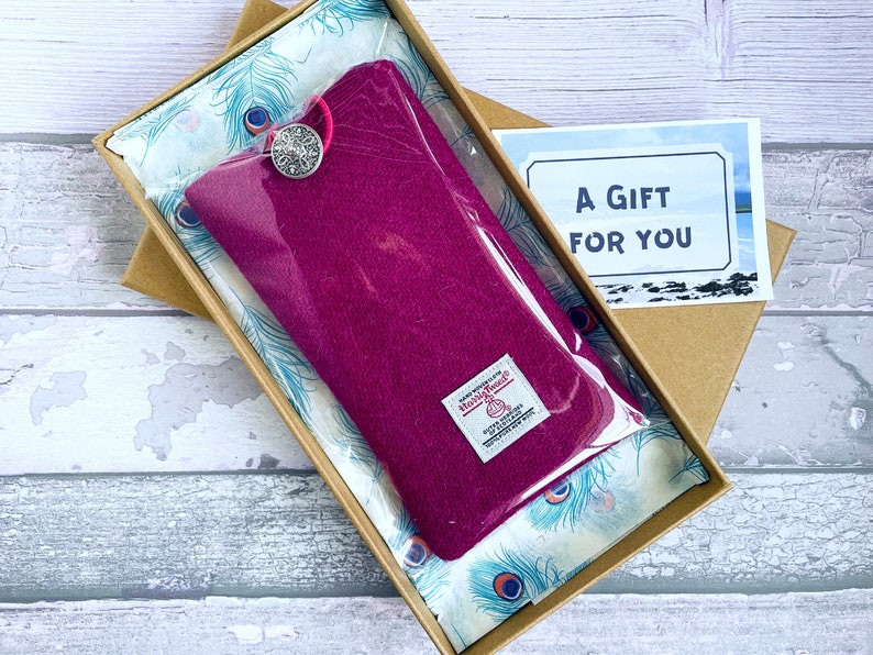 Pu&ograve; includere: Una custodia in lana magenta con chiusura a bottone argentato, dotata di etichetta Harris Tweed, confezionata in una scatola di cartone marrone foderata con carta velina a motivo di piume di pavone e un biglietto con scritto A GIFT FOR YOU.