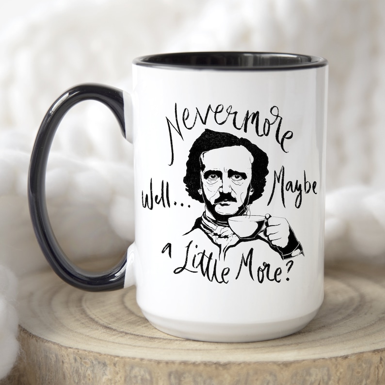 Puede incluir: Taza de cer&aacute;mica blanca con borde y asa negros. La taza presenta una ilustraci&oacute;n en blanco y negro de Edgar Allan Poe con el texto "Nevermore Well... Maybe a Little More?"