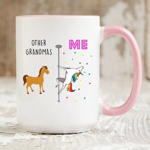 May include: White ceramic coffee mug with a pink rim and handle. The mug has a graphic of a unicorn on a pole dancing with the text "ME" above it. A brown horse is on the left side of the mug with the text "OTHER GRANDMAS" above it.