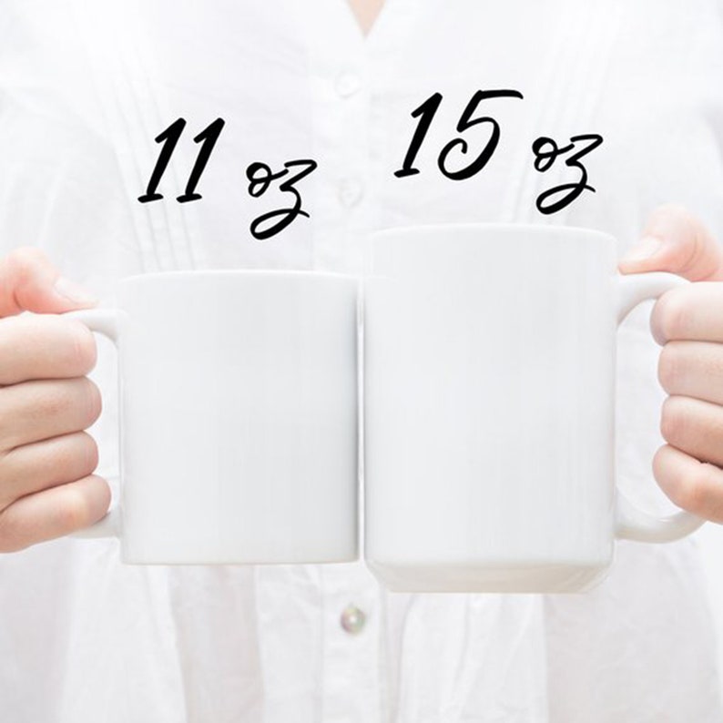 May include: Two white ceramic mugs, one 11 oz and one 15 oz, side by side.