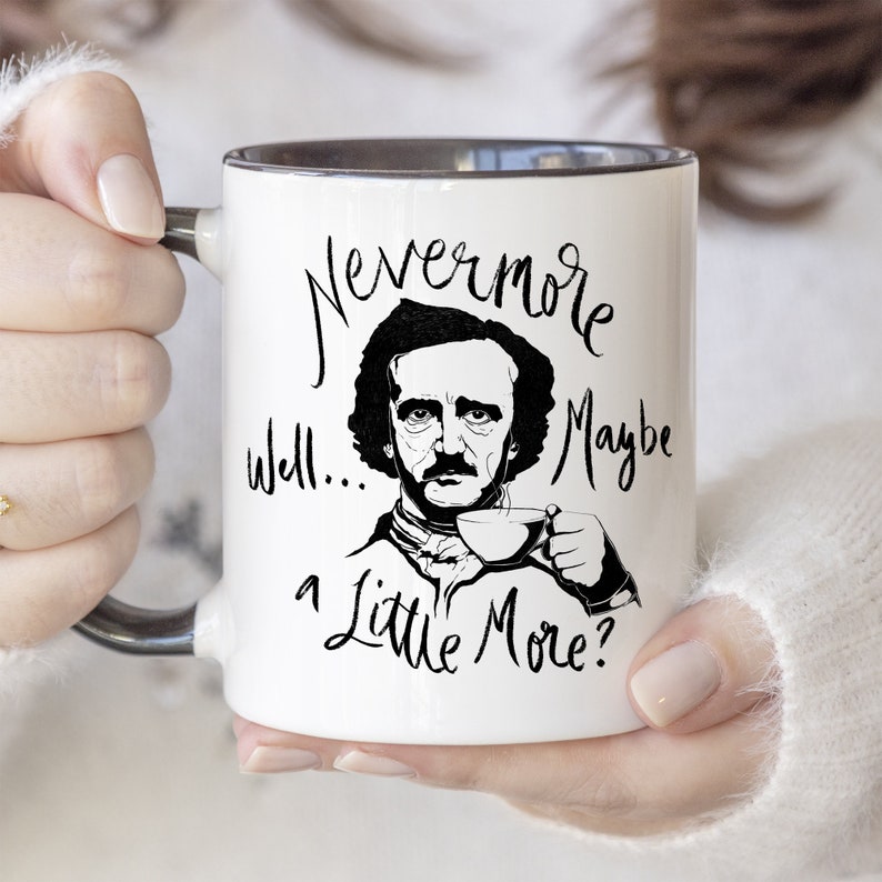 Puede incluir: Taza de cer&aacute;mica blanca con borde negro. La taza presenta una ilustraci&oacute;n en blanco y negro de Edgar Allan Poe con el texto "Nevermore well... a little more?"