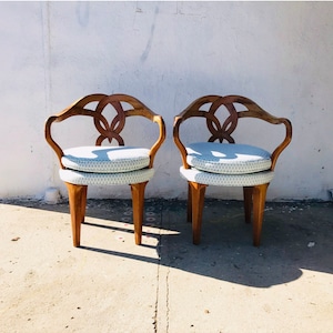 Puede incluir: Dos sillas de madera con cojines de estampado azul claro. Las sillas tienen un diseño único con respaldos y patas curvadas.