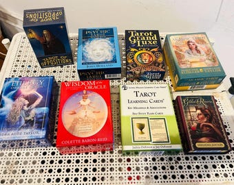 May include: A collection of eight tarot and oracle card decks including Tarot of Oppositions, The Psychic Tarot, Tarot Grand Luxe, The Akashic Tarot, Energy Oracle Cards, Wisdom of the Oracle, Tarot Learning Cards, and Gilded Reverie Lenormand.