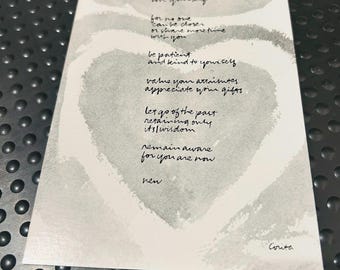 May include: A rectangular white card featuring a large, pale gray watercolor heart shape. The card contains black handwritten text that reads: love yourself, for no one can be closer or share more time with you, be patient and kind to yourself, value your attributes, appreciate your gifts, let go of the past, retaining only its wisdom, remain aware, for you are now, ren, Corita.