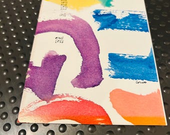 May include: A rectangular card featuring abstract watercolor brushstrokes in yellow, teal, blue, purple, red, and orange. The text reads: You are unlimited, like it less and less and less and less, end less, and Corero.
