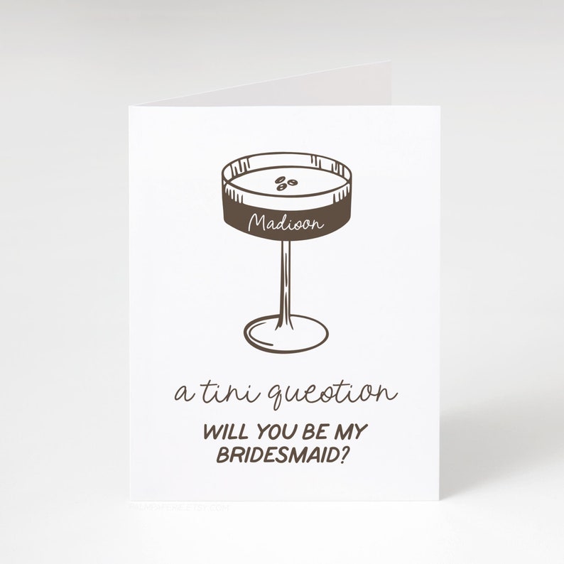Pode incluir: Um cart&atilde;o castanho com uma ilustra&ccedil;&atilde;o desenhada &agrave; m&atilde;o de um copo de martini com a palavra "Madioon" nele. O texto "a tiny question" e "Will you be my bridesmaid?" est&aacute; escrito abaixo do copo.