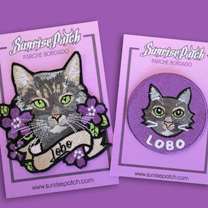 Puede incluir: Dos parches bordados para planchar que representan un gato con ojos verdes y la palabra "LOBO" en letras moradas. Los parches están sobre cartulina rosa con el texto "Sunrise Patch" y "Parche Bordado" en letras blancas.