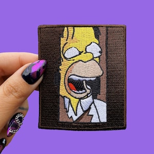 Puede incluir: Un personaje de dibujos animados amarillo con una expresión de shock está asomándose desde detrás de una puerta marrón. El personaje lleva una camisa blanca y una corbata marrón. La imagen es un parche bordado.