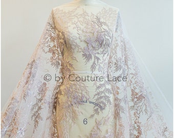 May include: A sheer fabric with a floral embroidery design in shades of pink and brown. The fabric is draped over a dress form.