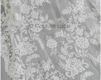 May include: White floral lace fabric with a delicate pattern. The lace is sheer and has a soft, flowing texture.  ©Couture Lace
