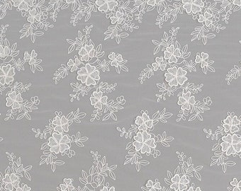 May include: White floral lace fabric with a delicate pattern. The lace is on a gray background.