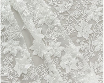 May include: White floral lace fabric with a delicate pattern of flowers and leaves. The lace is sheer and has a soft, flowing texture.