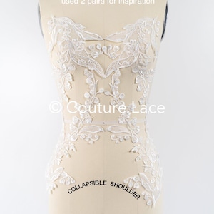 May include: White floral lace applique with a delicate design. The lace is shown on a dress form with the text "COLLAPSIBLE SHOULDER" and "6" visible. The text "used 2 pairs for inspiration" and "Couture Lace" are also visible.