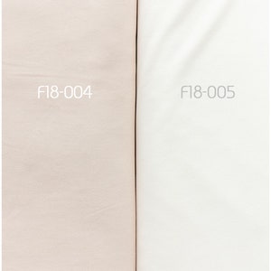 May include: Two fabric swatches side-by-side. The swatch on the left is a light pink color and labeled "F18-004". The swatch on the right is white and labeled "F18-005".