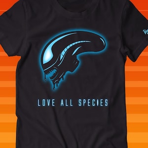 Op de afbeelding: Zwart T-shirt met een blauwe alienkop-afbeelding en de tekst "LOVE ALL SPECIES".