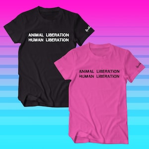 May include: Two t-shirts, one black and one pink, with the text "ANIMAL LIBERATION HUMAN LIBERATION" printed in white on the black shirt and black on the pink shirt. The shirts have short sleeves and a crew neck.