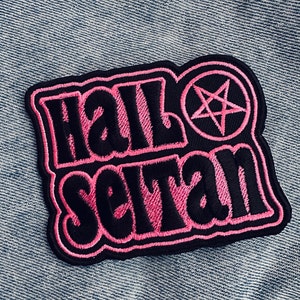 Puede incluir: Parche bordado en negro y rosa con el texto "Hail Satan" y un pentagrama.