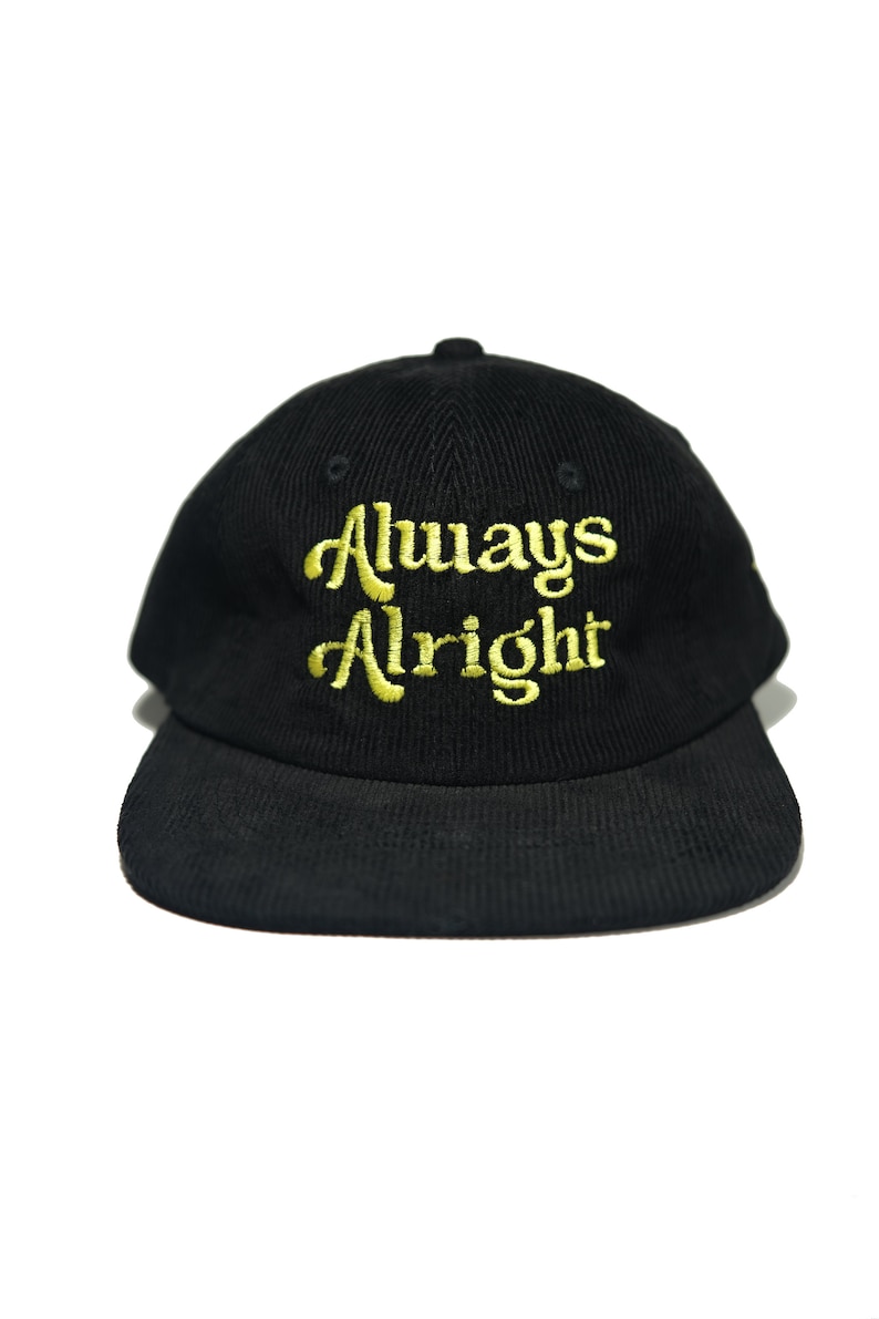 May include: Black corduroy baseball cap with a gold embroidered inscription that reads "Always Alright".