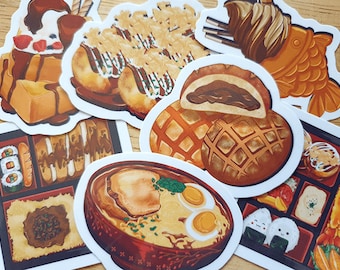 Op de afbeelding: Een verzameling kleurrijke stickers met illustraties van verschillende Japanse gerechten. De stickers bevatten ramen, sushi, taiyaki en andere populaire gerechten. Perfect voor het versieren van laptops, notitieboekjes of andere items.