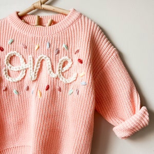 Bubblegum pink sweater, cream writing