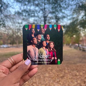 May include: A close-up of a colorful coaster featuring a group of people with the text "Abbott Elementary" and "This is how the honor rolls".