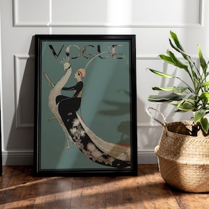 May include: A framed Vogue magazine cover art print. The artwork features a woman in a black dress and a peacock. The word "VOGUE" is at the top. The background is teal. The frame is black.