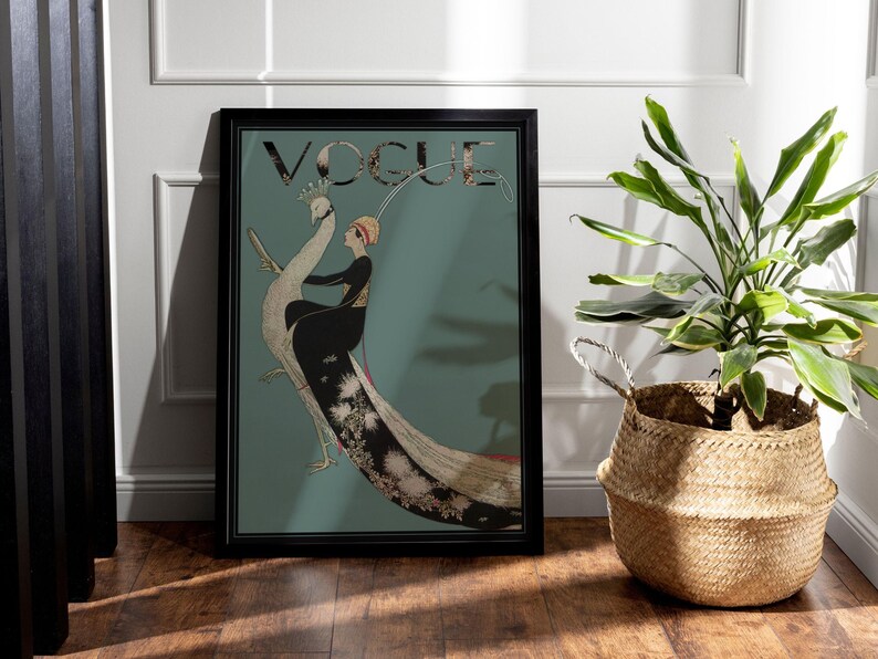 May include: A framed Vogue magazine cover art print. The artwork features a woman in a black dress and a peacock. The word "VOGUE" is at the top. The background is teal. The frame is black.
