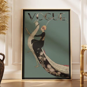 May include: A framed Vogue magazine cover featuring a woman riding a peacock. The artwork has a teal background with the word "VOGUE" at the top. The woman is wearing a black dress and a red hat. The peacock has a long, detailed tail.