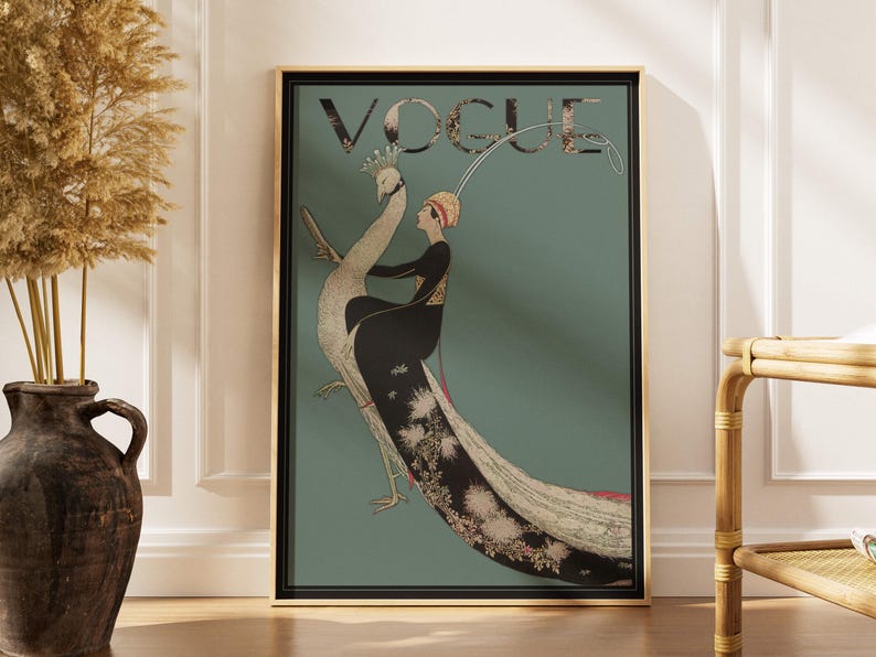 May include: Framed Vogue magazine cover art featuring a woman riding a peacock. The artwork has a teal background with the word "VOGUE" at the top. The woman is wearing a black dress and a red hat. The peacock has a long, flowing tail.