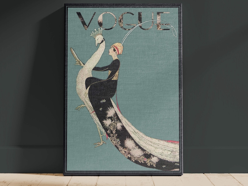 May include: A framed vintage Vogue magazine cover featuring a woman riding a peacock. The artwork has a teal background with the word "VOGUE" at the top. The woman is wearing a black dress and a gold headpiece. The peacock is white with a long, flowing tail.