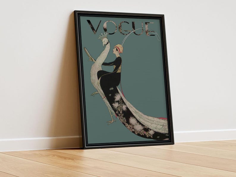 May include: Framed vintage Vogue magazine cover art featuring a woman riding a peacock. The artwork has a teal background with the word "VOGUE" at the top. The woman is wearing a black dress and a hat. The peacock has a long, detailed tail.