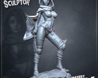 May include: A gray resin miniature figure titled Desert Blade by Nomadic Sculptor. The figure depicts a character wearing a hooded cloak, a cropped top, and fitted pants with leg wraps, standing on a rocky base while holding a curved blade.