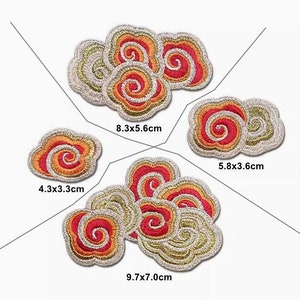Puede incluir: Cuatro parches bordados para planchar en forma de nubes con patrones en espiral en rojo, naranja y dorado. Los parches miden 4,3x3,3 cm, 5,8x3,6 cm, 8,3x5,6 cm y 9,7x7,0 cm.