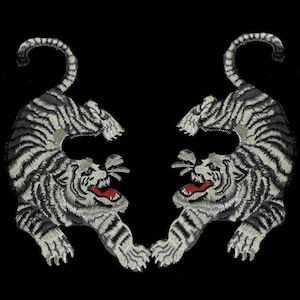 May include: Two white embroidered tiger patches with black stripes and red mouths. The tigers are facing each other with their tails curled up.