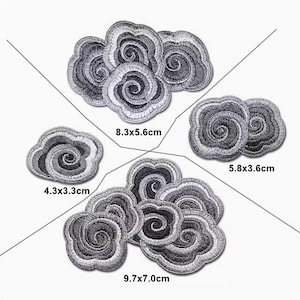 May include: Five silver embroidered patches in the shape of clouds with swirling designs. The patches are different sizes, with measurements in centimetres.