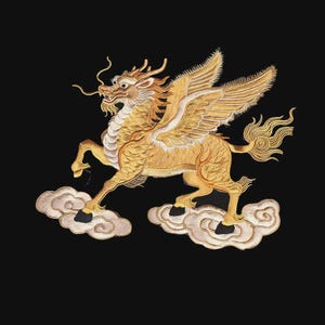 May include: A gold-colored embroidered patch featuring a mythical winged dragon with a horse-like body, flowing mane, and long whiskers. The creature is depicted in a dynamic pose, stepping onto stylized white and light gray clouds against a black background.