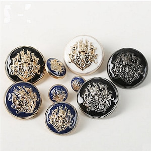 May include: Assortment of decorative buttons featuring a gold crest design. The buttons are in various colors, including black, white, and blue.
