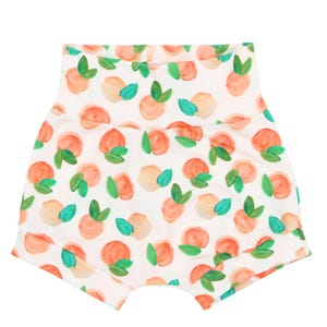 May include: White baby shorts with a peach and green print. The peaches are painted in a watercolor style.