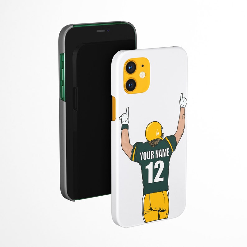 Puede incluir: Carcasa de tel&eacute;fono blanca con una ilustraci&oacute;n de un jugador de f&uacute;tbol americano verde y amarillo. El jugador lleva una camiseta con el texto "YOUR NAME" y el n&uacute;mero "12".