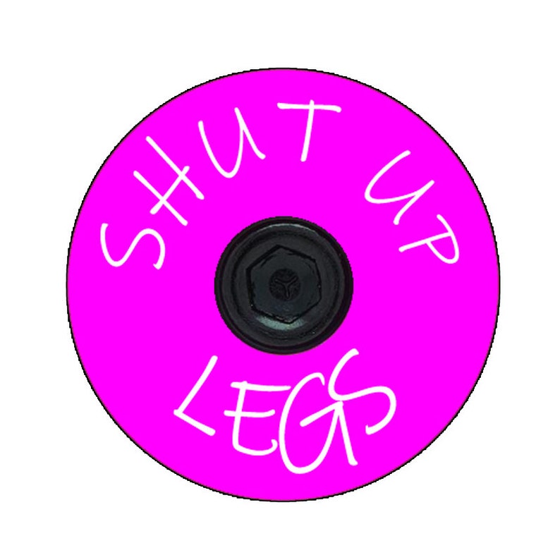May include: A bright pink bicycle stem cap with white text that reads "SHUT UP LEGS".