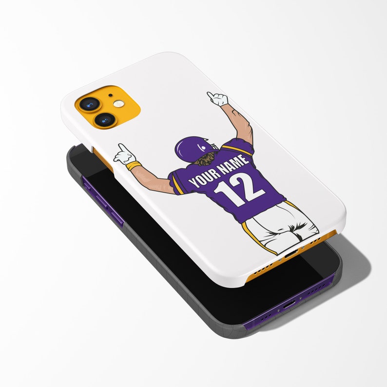 Puede incluir: Carcasa blanca para iPhone con un dise&ntilde;o morado y amarillo que presenta a un jugador de f&uacute;tbol americano celebrando un touchdown. La camiseta del jugador tiene el texto "YOUR NAME" y el n&uacute;mero "12" en la espalda.