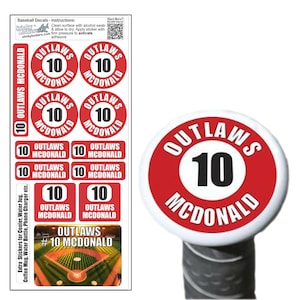 May include: A sheet of red and white baseball bat decals featuring the text "Outlaws #10 McDonald" in black. The decals come in a variety of sizes and shapes, including circles, squares, and rectangles. These decals are designed to be applied to baseball bats.