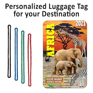 May include: Personalized luggage tag with a sunset scene of Africa. The tag features a giraffe, elephants, and a zebra. The text "AFRICA" is written vertically in yellow letters. The year "2021" is in the top right corner. The text "YOUR NAME GOES HERE" is at the bottom of the tag.