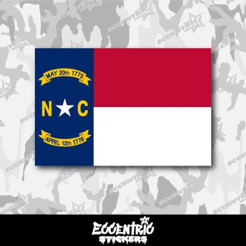 K&ouml;nnte beinhalten: Ein Aufkleber mit der Flagge des Bundesstaates North Carolina. Die Flagge ist blau mit einem gelben Stern in der Mitte und den Buchstaben "N*C" &uuml;ber dem Stern. Die Flagge ist von einem gelben Band mit den Daten "MAY 20th 1775" und "APRIL 12th 1776" umgeben. Die Flagge befindet sich auf einem wei&szlig;en Hintergrund mit einem Tarnmuster.
