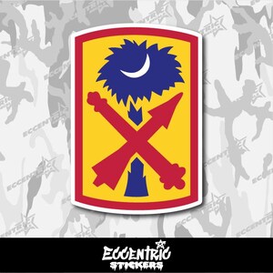 May include: A sticker featuring a yellow and red shield with a blue tree and crescent moon design. Two red arrows cross in the center. The sticker has a white border and the text "ECCENTRIC STICKERS" in a stylized font.