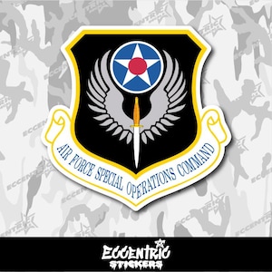 May include: A sticker featuring the Air Force Special Operations Command emblem. The design includes a black shield with a yellow border, a blue and red star, wings, and a dagger. The text "AIR FORCE SPECIAL OPERATIONS COMMAND" is displayed.
